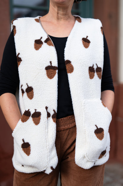 Vorderansicht der Teddyweste Acorn Hug mit braunen Eicheln und aufgesetzten Taschen über schwarzem Shirt